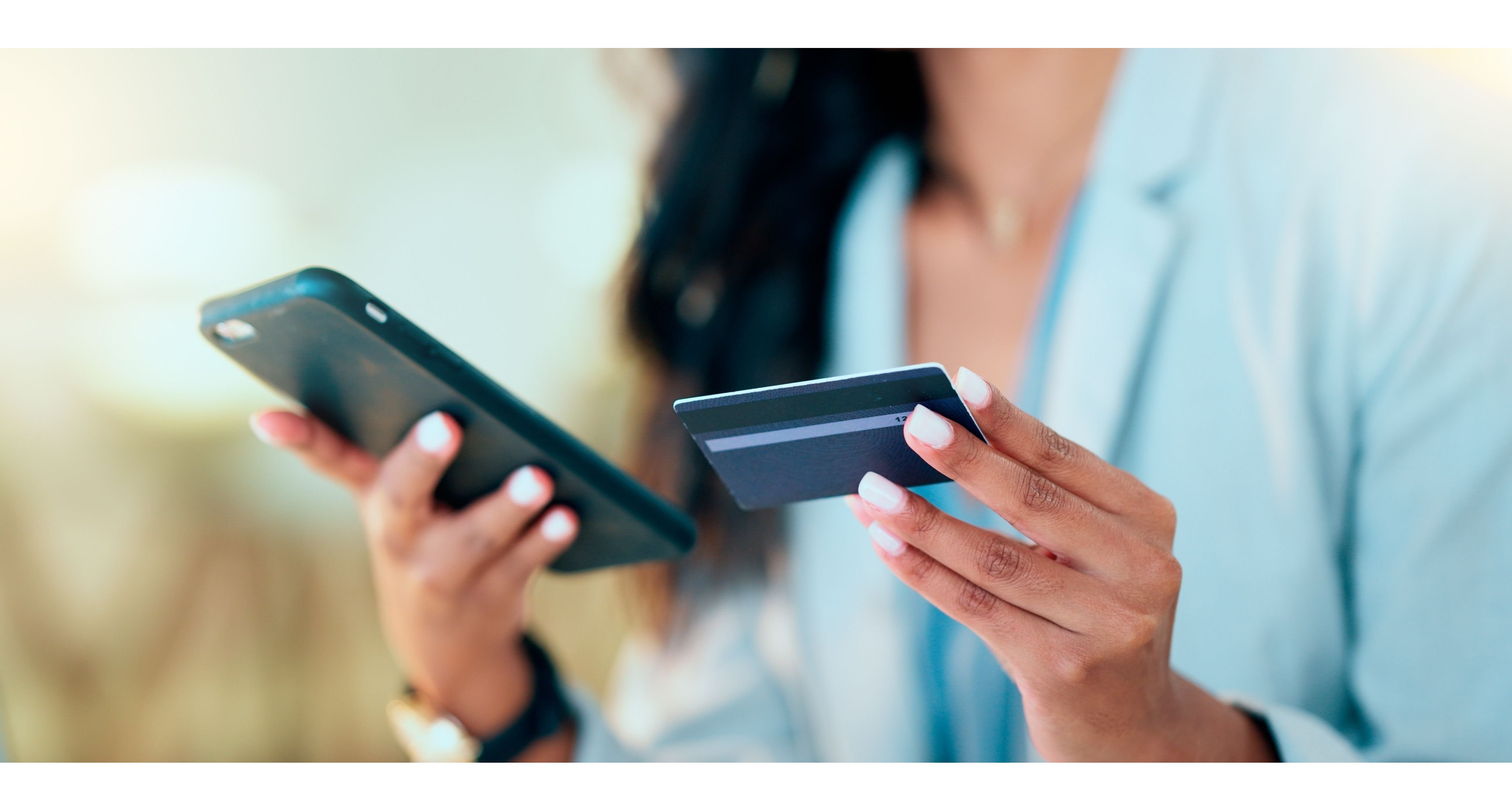 Bank card data put in phone by a lady who does internet banking by typing on her mobile to make an online credit payment. Young woman texting on her phone to send money via an ewallet transaction